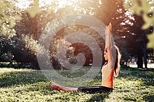 Yoga. Young woman practicing yoga or dancing or stretching in nature at park. Health lifestyle concept