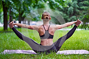Yoga. Young woman practicing yoga meditation in nature at the park. Health lifestyle concept