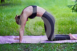 Yoga. Young woman practicing yoga meditation in nature at the park. Health lifestyle concept