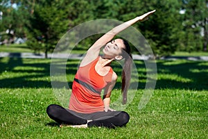 Yoga. Young woman practicing yoga meditation in nature a park. Health lifestyle concept