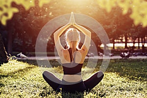 Yoga. Young woman practicing yoga meditation in nature at the park. Health lifestyle concept