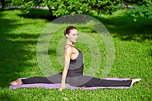 Yoga. Young woman practicing yoga meditation in nature at the park. Health lifestyle concept