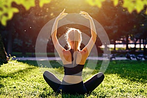 Yoga. Young woman practicing yoga meditation in nature at the park. Health lifestyle concept