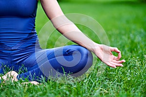 Yoga. Young woman practicing yoga meditation in nature at the park. lotus pose. Health lifestyle concept