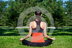 Yoga. Young woman practicing yoga meditation in nature a park. lotus posture. Health lifestyle concept