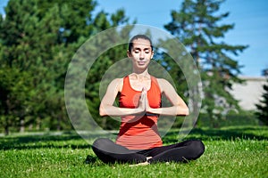 Yoga. Young woman practicing yoga meditation in nature a park. lotus posture. Health lifestyle concept