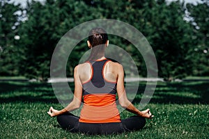 Yoga. Young woman practicing yoga meditation in nature a park. lotus posture. Health lifestyle concept