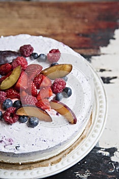 Yoghurt cake with berries on a vintage plate on the background of an old table