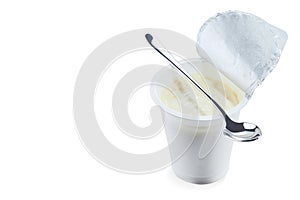 Yoghurt flavored banana in an open plastic Cup with a beautiful elegant spoon isolated on a white background.