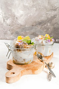 Yoghurt with granola, orange, mint and edible flowers