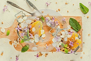 Yoghurt with granola, orange, mint and edible flowers