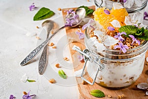 Yoghurt with granola, orange, mint and edible flowers