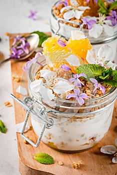 Yoghurt with granola, orange, mint and edible flowers