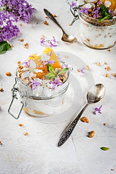 Yoghurt with granola, orange, mint and edible flowers