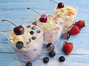 Yoghurt, oatmeal blueberry organic strawberry homemade dairy delicious refreshment apricot cherry on a blue wooden background