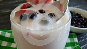 Yoghurt raspberry strawberry blueberry spoon slow motion