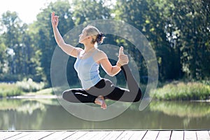 Yogi female doing One-legged king pigeon pose in mid air