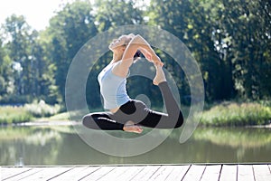 Yogi female doing Royal Pigeon pose in mid air