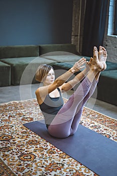 Yogi Female Practicing Yoga Boat Pose on Mat in Vintage Living Room, Paripurna Navasana Exercise, Sport Workout Style