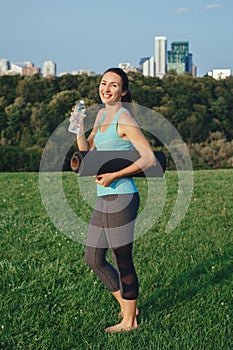 Yogi girl drinking water after workout.