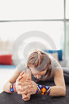 Yogi girl practicing Janu sirshasana or Head-to-Knee Forward Bend Pose