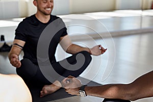 Yogi men and women practicing yoga in fitness gym