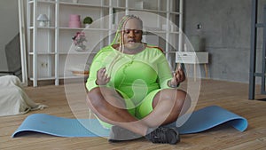 Yogi plump african woman meditating in lotus pose