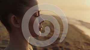 Yogi woman meditating closing eyes on sandy beach close up. Girl feeling harmony
