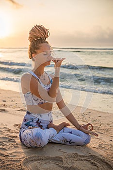 Yogi woman sitting in lotus pose, practicing Anuloma Viloma Pranayama, Alternate Nostril Breathing. Control prana, control of