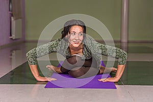 Yogi woman stretches yoga poses in a studio