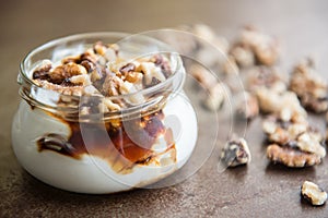 Yogur with nutz in a glass and caramel