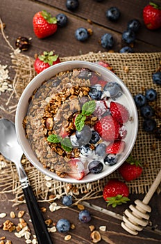 Yogurt with baked granola and berries in small bowl
