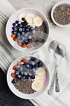 Yogurt with berries, banana, almonds and Chia seeds, bowl of healthy Breakfast every morning, vintage style, superfood and detox