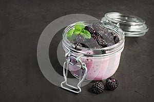 Yogurt and black raspberries in a glass jar