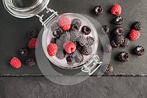 Yogurt with black and red raspberry in glass jar