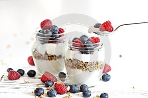 Yogurt with bluberry and raspberry in the glass jars