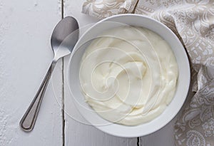 Yogurt bowl with natual creamy white Greek yoghurt on white rustic table close up