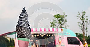 Yogurt charcoal or black sesame ice cream on cone with vintage sweet pastel color food truck background, copy space