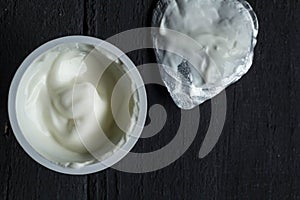 Yogurt cup with natural Greek yoghurt in plastic cup with foil l