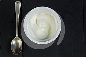 Yogurt cup with natural Greek yoghurt in plastic cup with silver
