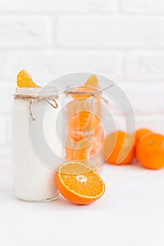 Yogurt with fresh orange slices and whole oranges