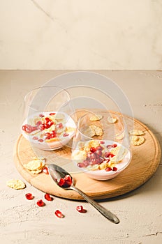 yogurt with garnet grains and flakes in glass/yogurt with garnet grains and flakes in glass on a wooden tray and white stone