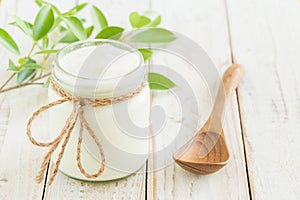 Yogurt in glass bottles on white wooden table Healthy food concept