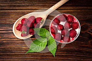 Yogurt with granola, raspberry and raspberry jam on dark wooden background