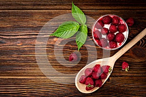 Yogurt with granola, raspberry and raspberry jam on dark wooden background