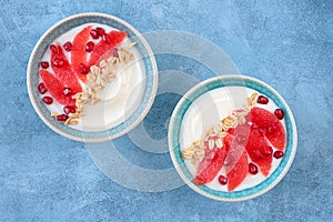 Yogurt with granola and red grapefruit, pomegranate for healthy breakfast. Bowl of greek yogurt with granola , honey and fresh