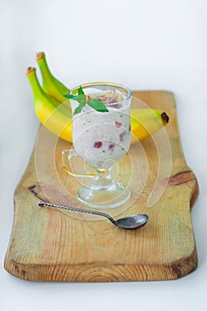 Yogurt Jelly Dessert with banana, strawberry, cocoa, fresh mint in a glass on wooden cut board.Healthy vegan sweet jello