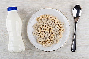 Yogurt, oat flakes in form rings in plate, spoon