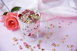 Yogurt parfait with fresh raspberry berries and rose on a light pink background. Healthy food. With copy space for text