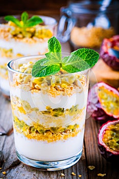 Yogurt parfait with granola, peach sauce and passion fruit with mint